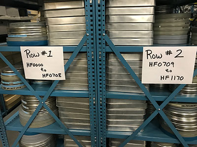 stacks of round metal canisters containing motion picture films
