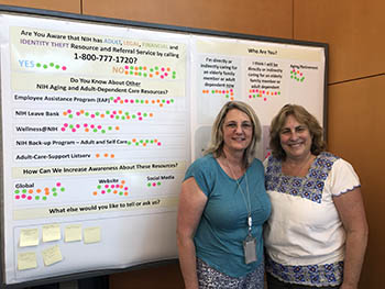 Linda Kiefer (left) and Deborah Henkin (right) are standing in front of a poster