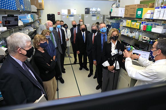 senators, staff, and NIHers in a lab; all wearing masks