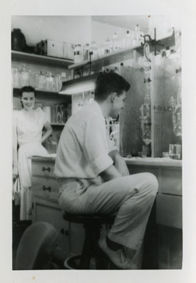 Caroline Rall (in background) and Ed Rall (sitting) in lab