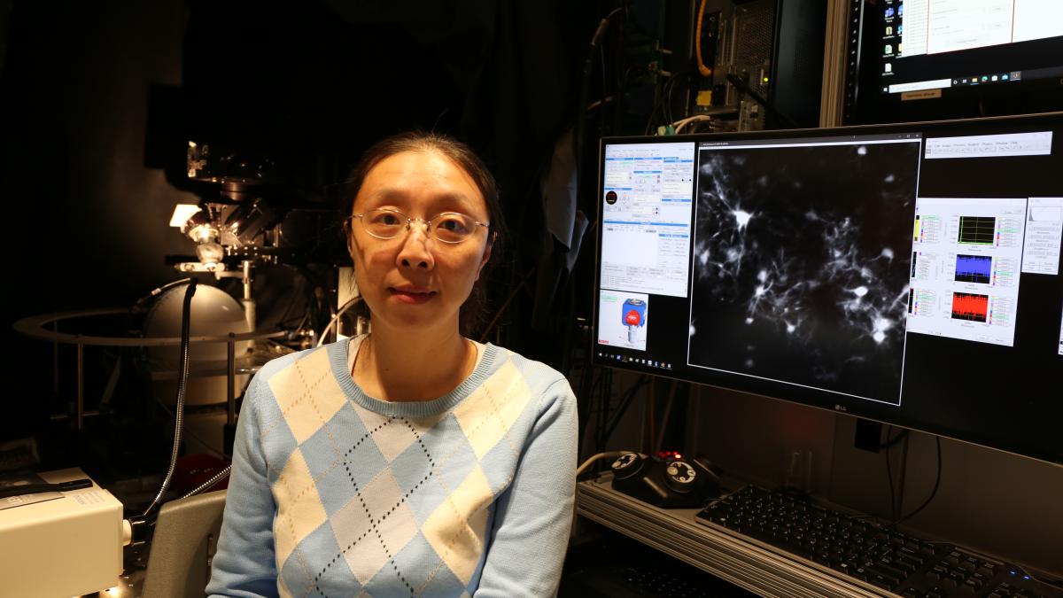 Dr. Yi Gu poses with her lab's two-photon microscope