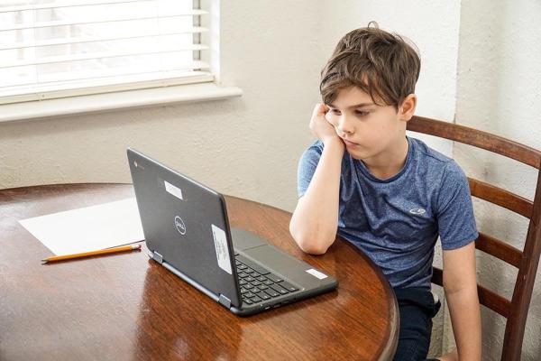 unhappy kid looking at laptop