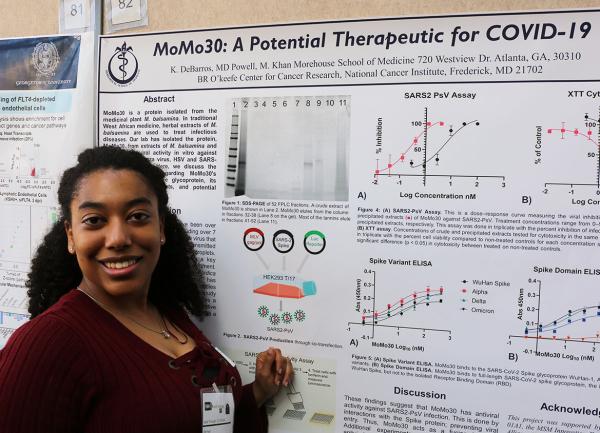IRP graduate student Kenya Debarros poses with her scientific poster