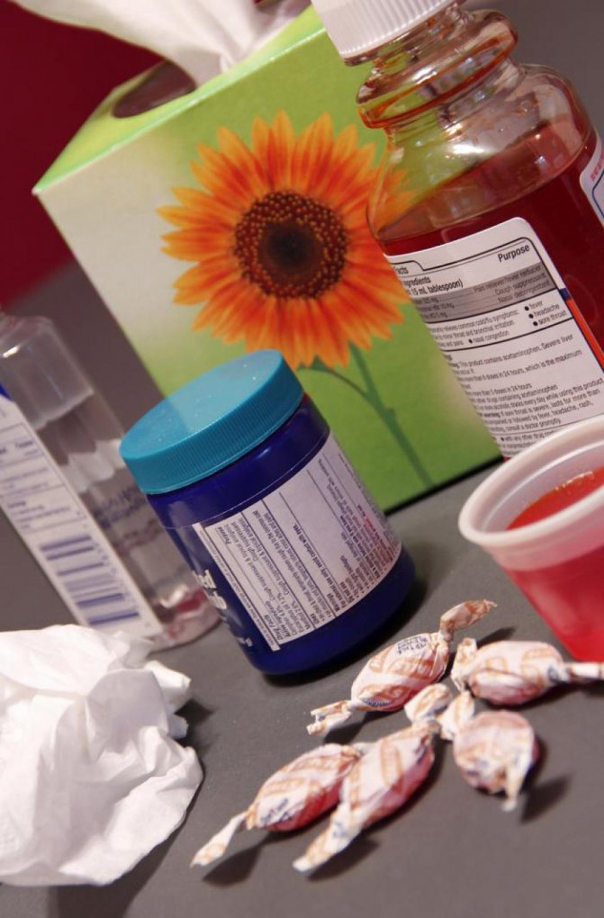 Photo of an assortment of cold medicines beside a box of tissues.