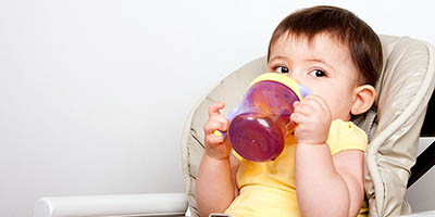 toddler drinking juice from a sippy cup