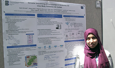 NIH Postbac IRTA Sarah Ahmed posing with her poster at Postbac Poster Day