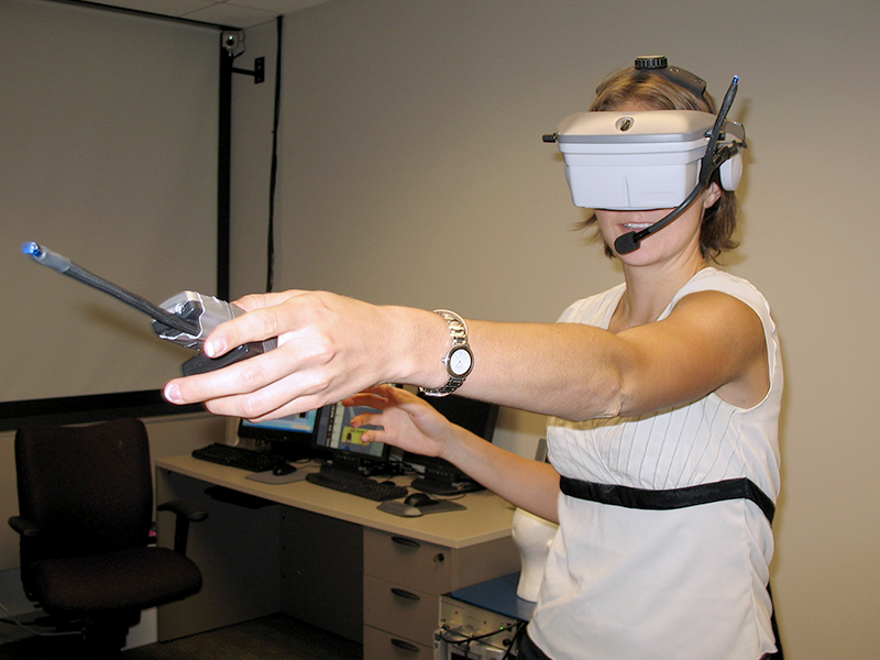 A summer student in the lab of Susan Persky, Ph.D., tests out a virtual reality headset