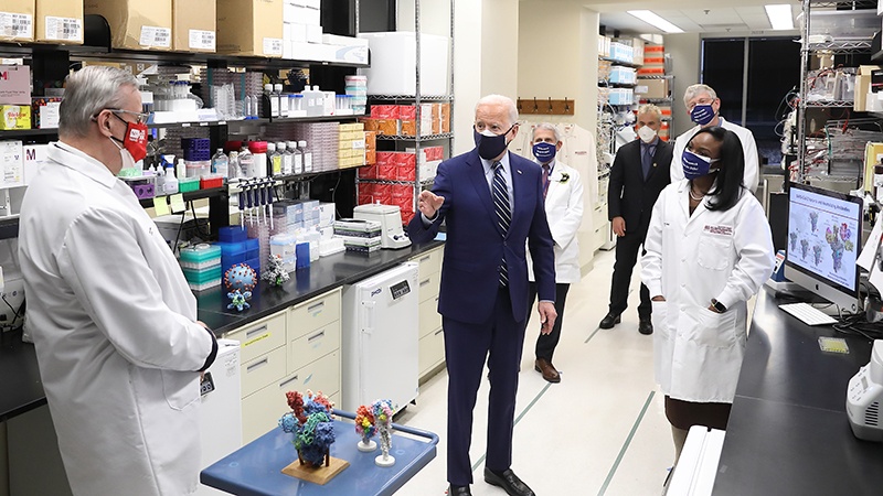 President Joe Biden visits Dr. Graham (foreground, left) and Dr. Corbett (far-right) at the VRC in February 2021.