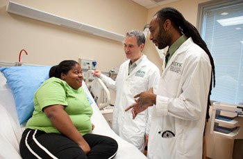 NIH clinicians talk to an African American patient