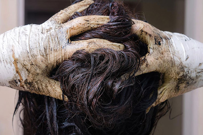 woman rubbing hair dye into her hair