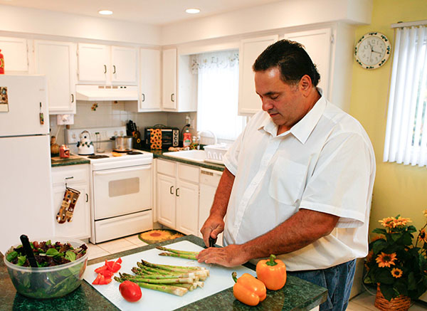 man chopping vegetables in his kitchen