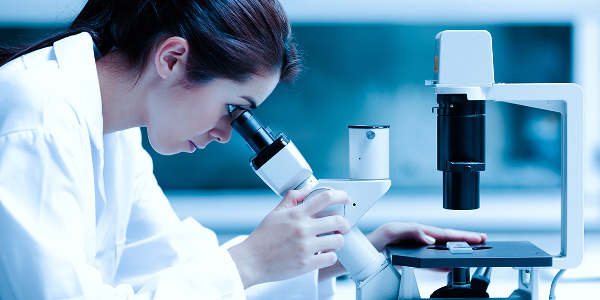 female scientist looking into a microscope