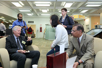 Young, seated, talking to people in the NIH Library