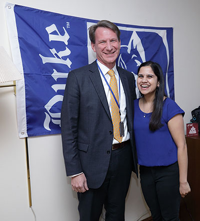  Ned Sharpless and Nicole Dalal in front of Duke banner hanging on wall in Dalal's room.