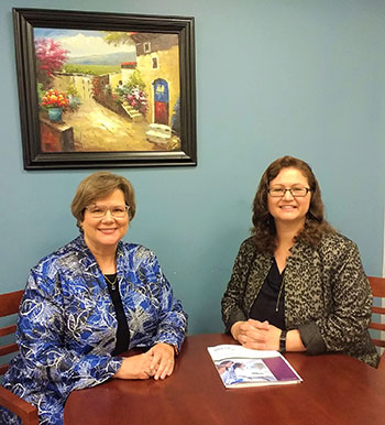 Lynn Johnson Langer (left) and Christina Farias (right) sitting at a table