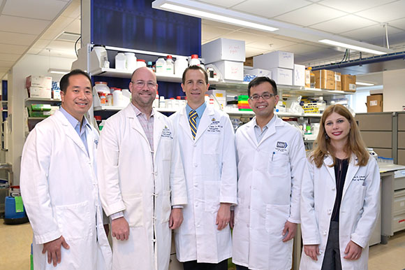 The five new surgeons in a group photo in a lab.