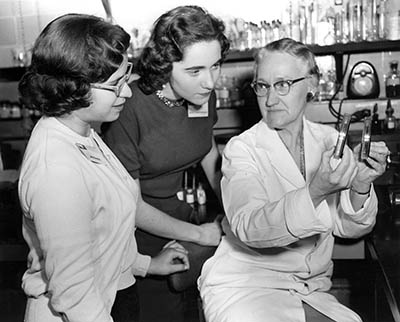 two young women talking with Margaret Pittman in her lab.