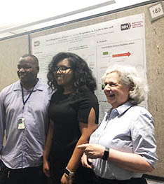 three people standing in front of a poster