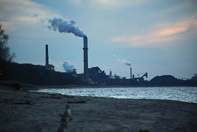 steel mills with smoke coming out of tall smokestacks