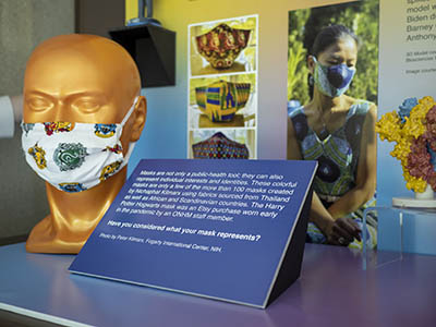 head model wearing a mask; image of masks in background