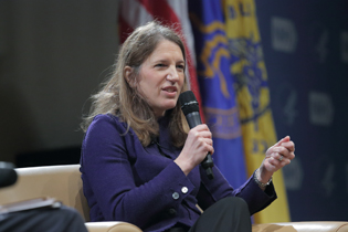 Sylvia Burwell holding a microphone as she answers questions.