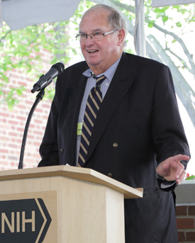 Lowell Weicker at the podium in front of building 4