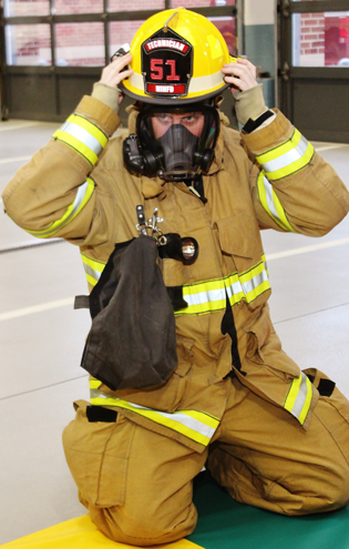 firefighter with fire hat, mask, coat, and other safety gear
