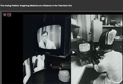 TV screens--one with a clinician, the other showing video microscopy of a blood smear.