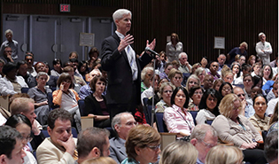 Andrew Griffith standing in a crowd in the auditorium.