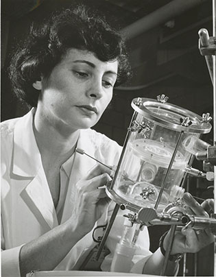 Nina Braunwald looking at a large glass container that she's holding
