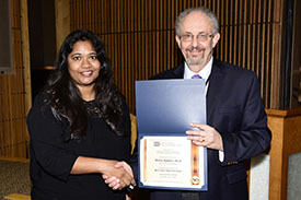 woman and man holding an award certificate