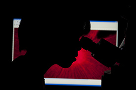  silhouette of person looking through a microscope