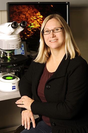 Serena Dudek in her lab, next to a big microscope