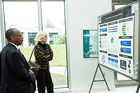 A MAN AND A WOMAN LOOKING AT A POSTER