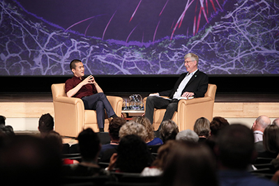 Ed Yong and Francis Collins sitting in armchairs on stage