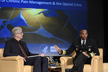 Francis Collins and Jerome Adams sitting on stage at the symposium.