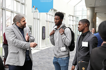 Jeremiah Smith chatting with two male students