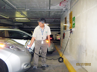 man fueling up his electric car with an electric cord