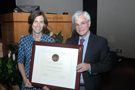 Jennifer Lippincott-Schwartz and Michael Gottesman holding large framed plaque