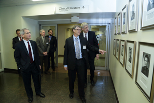 Tony Fauci, Bill Gates, and Francis Collins looking at photos on wall