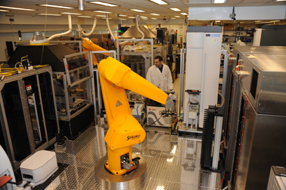 yellow robot in foreground looks like a giant hinged arm; man in background