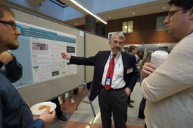 Dan Kastner pointing at his poster while others look on