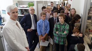 Andrew Griffith (left) and a group of children and adults outside lab area