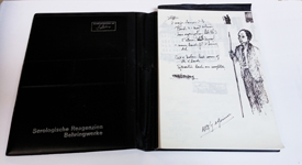 Open notebook with written notes and a sketch of a man