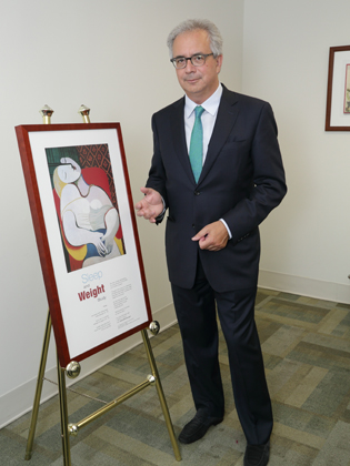 Giovanni Cizza standing next to a framed poster