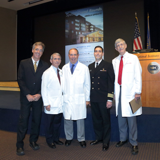 five men standing in front of the podium in Masur Auditoriam