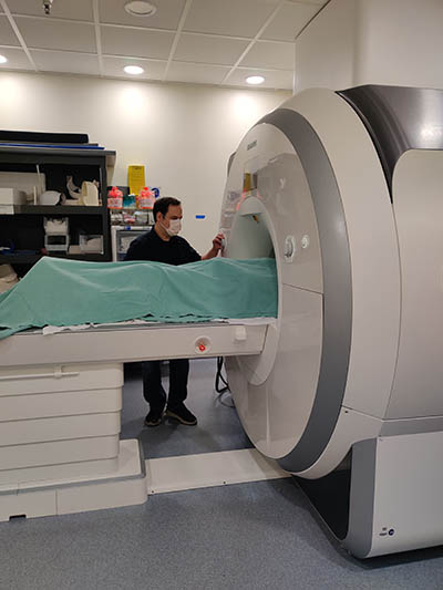 person standing next to MRI scanner