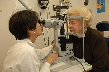 female doctor (left) administering eye exam to a woman patient