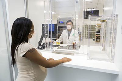 woman at the pharmacy window; pharmacist inside