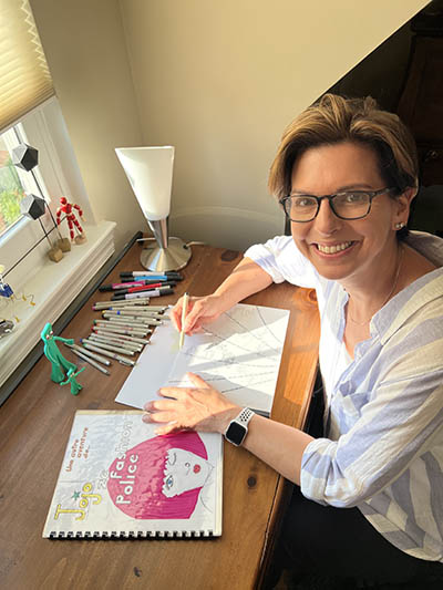 Elodie sitting at her cartooning desk